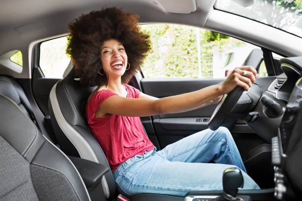 istock Cheerful young woman driving car in daylight 1577832988