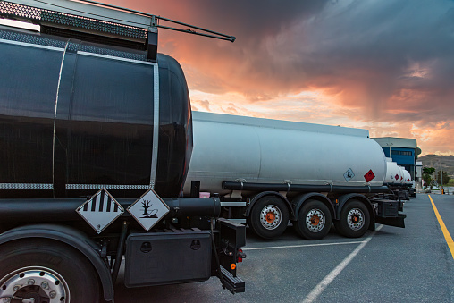 Rear of several parked dangerous goods tankers where the danger labels can be seen.