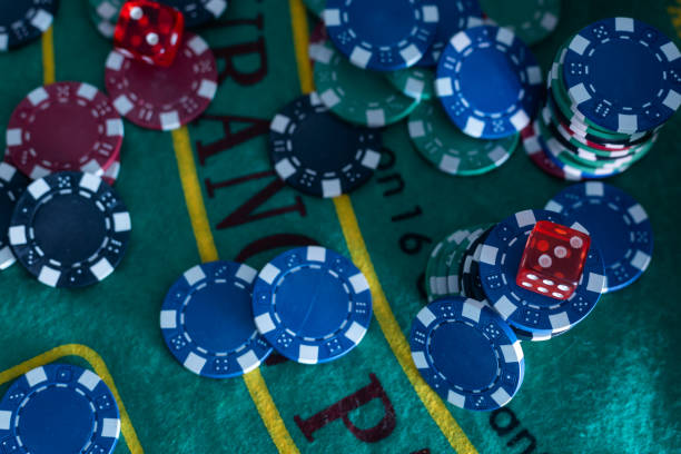 istock Image of several red dice falling on green table on background of multicolored spots 1577943811