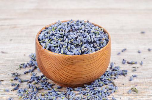 Dried Lavender buds in a wooden cup for herb medicine or tea.