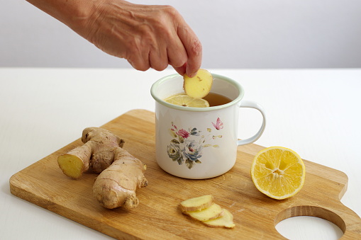 Cropped photo of woman's hand preparing ginger tea