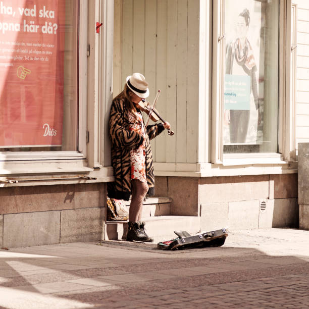 Ostersund, Norrland Sweden - July 10, 2020: female fiddler standing at corner and playing violin