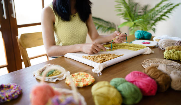 istock Punch needle. Asian Woman making handmade Hobby knitting in studio workshop. designer workplace Handmade craft project DIY embroidery concept. 1578017466