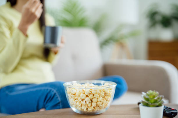 istock Asian woman Watching smart TV and using remote controller Hand holding television audio remote control at home with the remote control television 1578046169