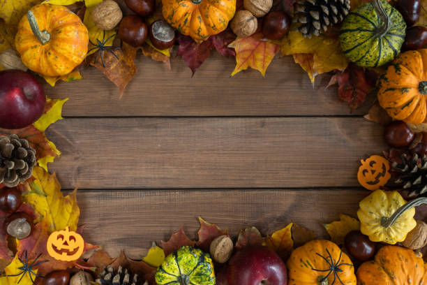 istock Autumn flat lay composition frame for Halloween, with pumpkins, decorations on fall leaves and copy space on  wooden background. 1578048276