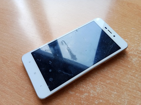 The smartphone is white, where the screen looks a little dirty