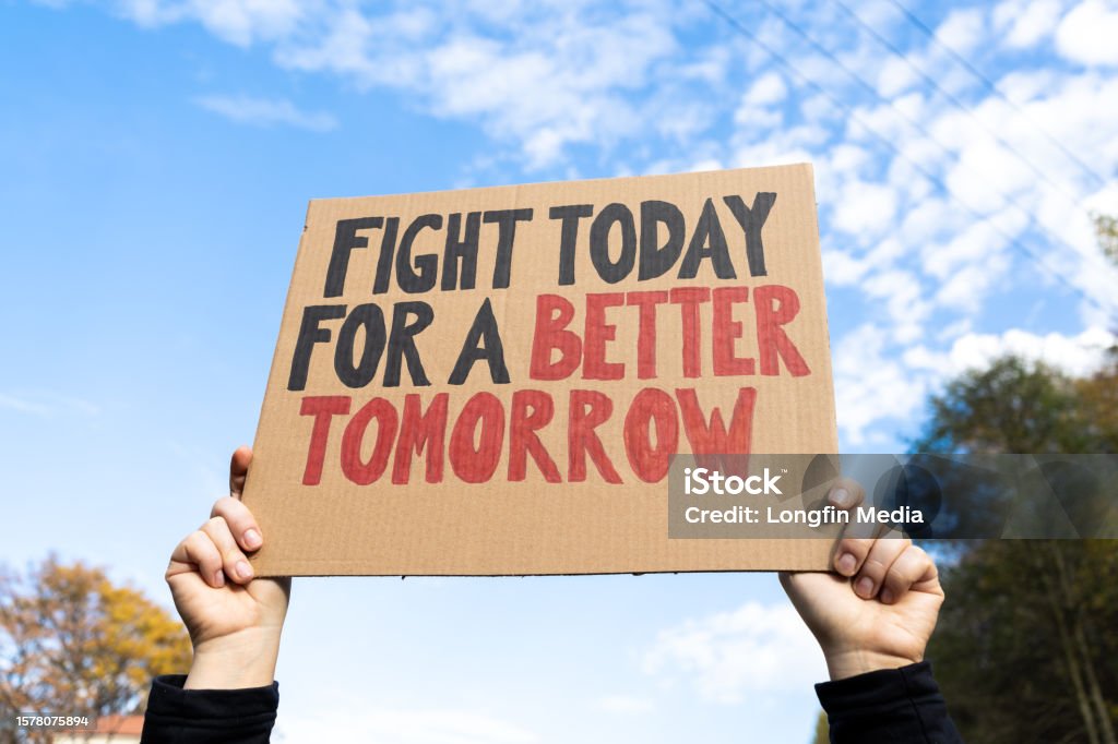 Hands holding placard sign with text Fight Today For a Better Tomorrow. Woman holding placard sign with text Fight Today For a Better Tomorrow. Female protestor with cardboard banner at protest rally demonstration. Justice - Concept Stock Photo
