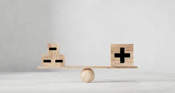 Photo of One big dice plus and many small dice. On wooden scales on a white background.