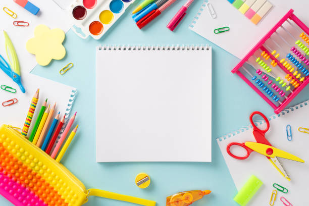 istock Embark on a learning adventure with this creative top view composition: colorful collection of childish school supplies on serene pastel blue surface, with blank notebook page for text or advertising 1578093560