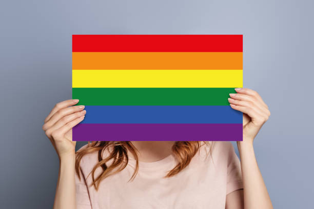 istock female hands holds speech bubble with LGBT flag community isolated on blue background 1578095793