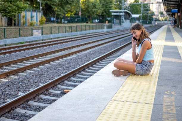 istock Beautiful girl using mobile phone to subway station 1578114335
