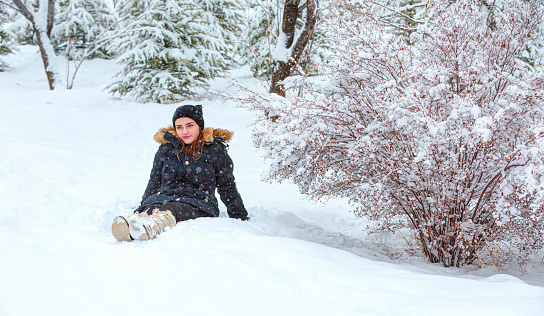 Girl outdoor in a winter day, snowy trees in forest,