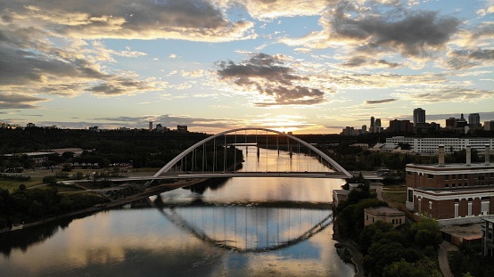 A picturesque scene of the Walterdale Bridge over a body of water at sunset in Edmonton