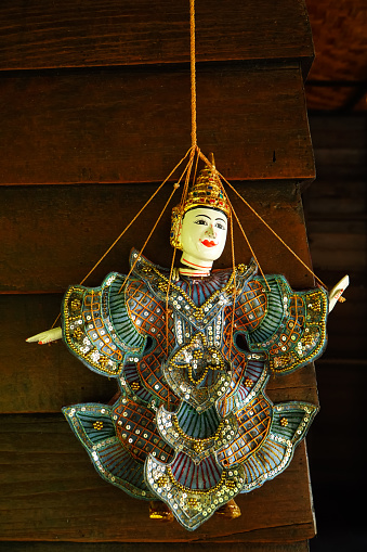 Myanmar puppet on wall background. Old Burma string marionette hanging beside wood wall for decoration