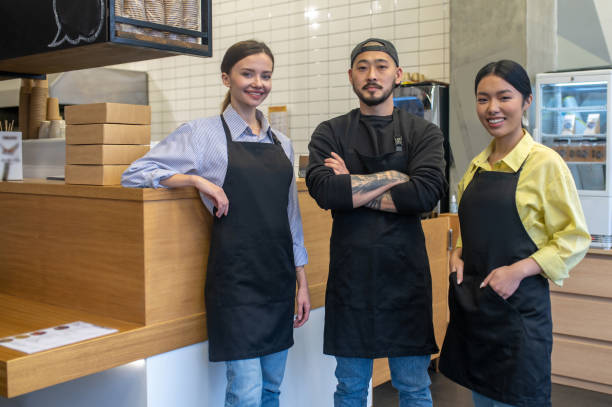 istock Team of young cafe workers standing together and looking contented 1578199278