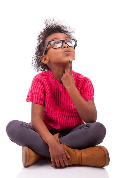 Young girl sitting cross-legged on the floor stock photo