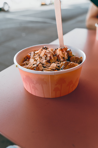 Poke bowl on a table outdoors with a wooden fork