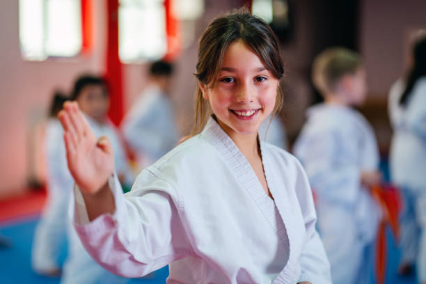 istock little girl training during a karate class, looking at camera and smiling 1578262580