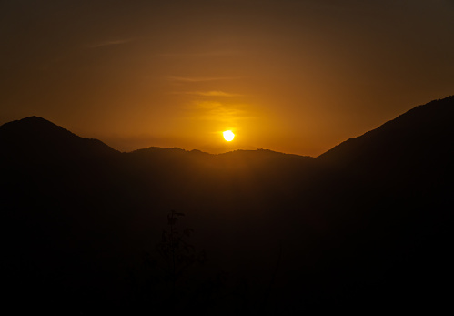 Sunrise over Himalayan mountain ridge, creating mountain peak silhouettes. Stock media, Uttarakhand, India.