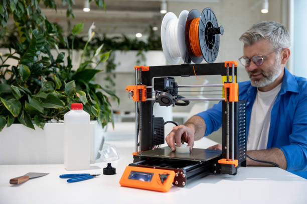 istock Modern 3D printer equipment and man working with it in office. 1578295351