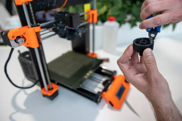 istock Modern 3D printer equipment and man working with it in office. 1578295883