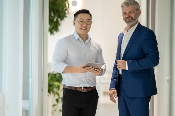istock Men standing in corridor in office and talking about their work. 1578298025