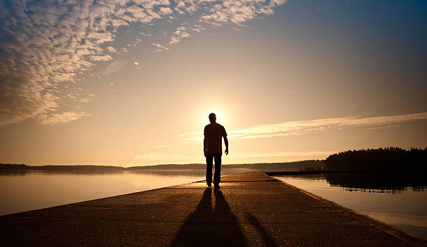 istock Man goes on concrete pier in the sunrise 157831202