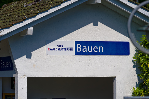 Shelter at pier of Swiss village Bauen with blue and white sign on a sunny spring day. Photo taken May 22nd, 2023, Bauen, Switzerland.