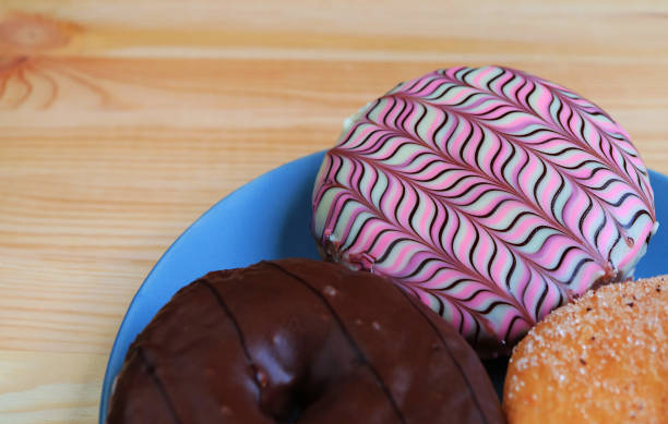 istock Plate of assorted doughnuts with selective focus served on wooden table 1578337286