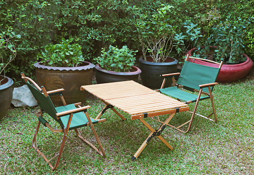 Pair of Portable Folding Chairs and a Wooden Table in the garden