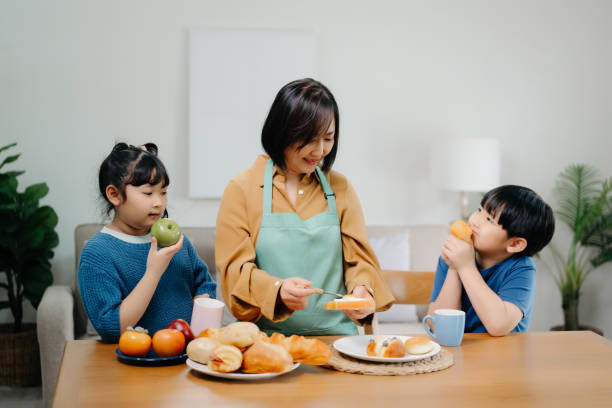 happy asian family father and mother little toddler asian boy daughter child having fun cooking together with dough bake cookie and cake ingredient on table - two parent family indoors home interior domestic kitchen imagens e fotografias de stock