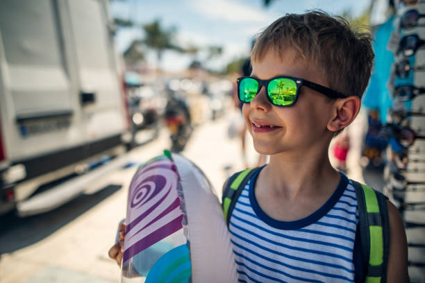 Little boy going to the beach. The boy is holding an inflatable ring. Summer sunny day in Andalusia, Spain.\nShot with Nikon D810