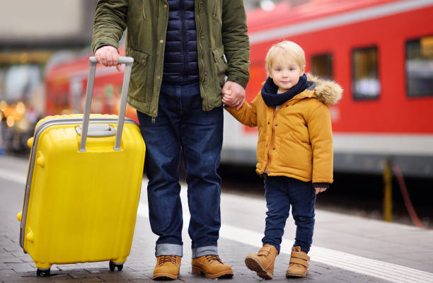 istock Smiling little boy and his father waiting express train on railway station platform 1578368297