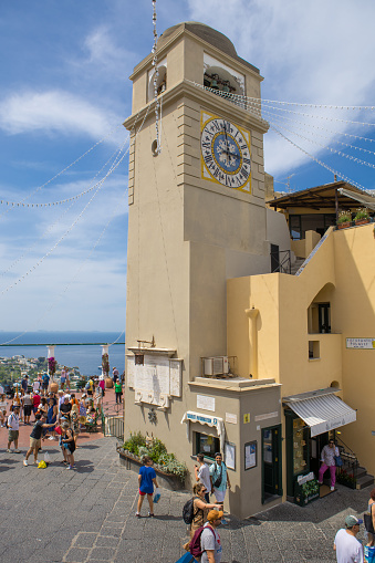 Capri, Italy - June  19, 2023: Capri main square and bell tower with tourists