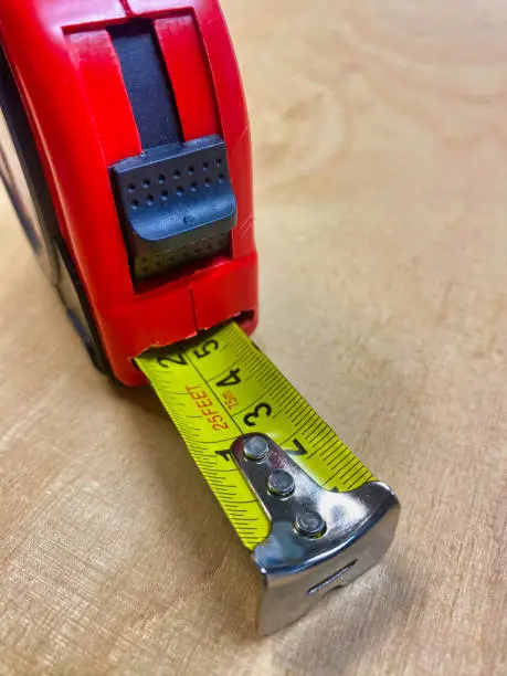 Photograph of a tape measure on a wooden tabletop