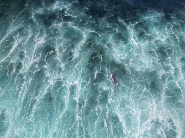 istock a person standing in the water looking down at an ocean wave 1578409958