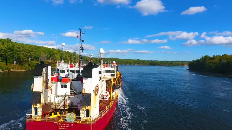 Pan around back of Commercial ship from above sailing through river in Maine