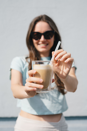 Happy woman holding iced coffee glass