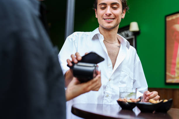 istock Paying the bill with mobile phone at the bar 1578443389