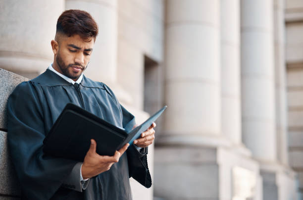 Lawyer man, street and reading documents for case, court battle or focus with information for criminal defence. Young attorney, paperwork and preparation for litigation, evidence and justice system