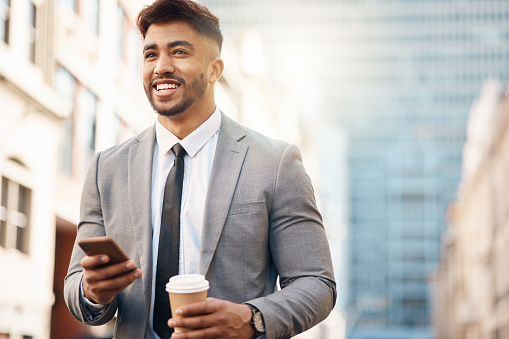 Phone, happy and business man in city online for social media, networking and website in town. Travel, professional and hands of male worker with coffee and smartphone for internet on morning commute