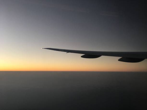 istock Airplane flight in sky above clouds sunset dusk 1578457904