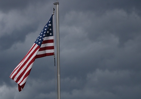The red, white and blue stands out with storm clouds rolling in.
