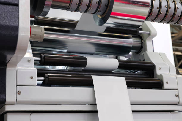 istock Automatic industrial machine for plastic packaging with light effect of products and food. shaft of an automated packaging line with plastic film in a light blue scene. product packaging concept 1578521606