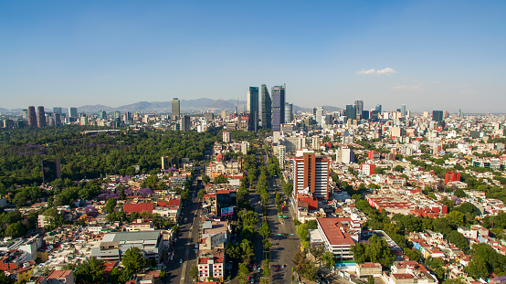 Toma aérea de la Ciudad de México en donde se aprecia la zona urbana y de fondo los edificios más altos de la ciudad .