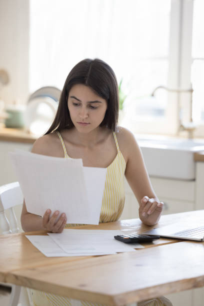 istock Serious young woman reading domestic residential documents 1578560410