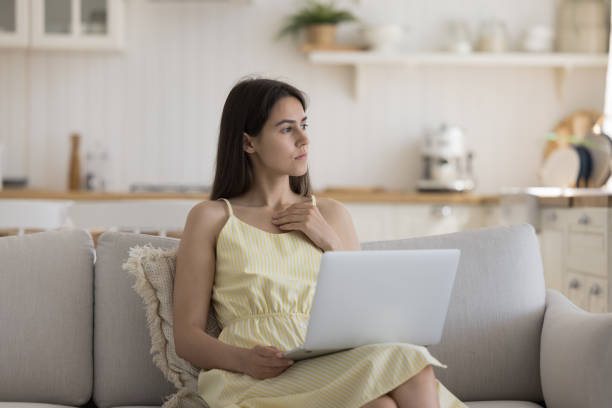 istock Thoughtful pretty young freelancer woman working at home 1578561043