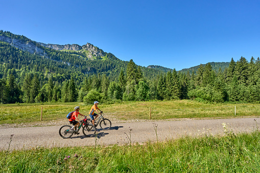 two senior girl friends having fun during a cycling tour in the Rohrmoos Valley near Oberstdorf Allgau Alps, Bavaria Germany