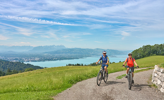 two senior girl friends having fun during a cycling tour at Lake Constance above City of Lindau, Bavaria, Germany