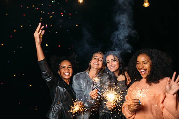 istock Four diverse women having fun outdoors holding sparklers and throwing confetti 1578667082